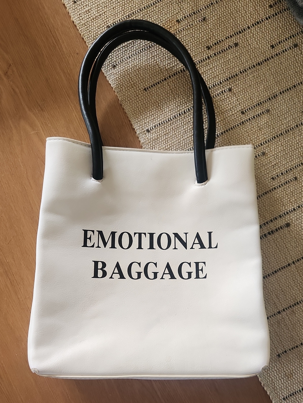White Tote Bag with Black Handles and 'EMOTIONAL BAGGAGE' Text